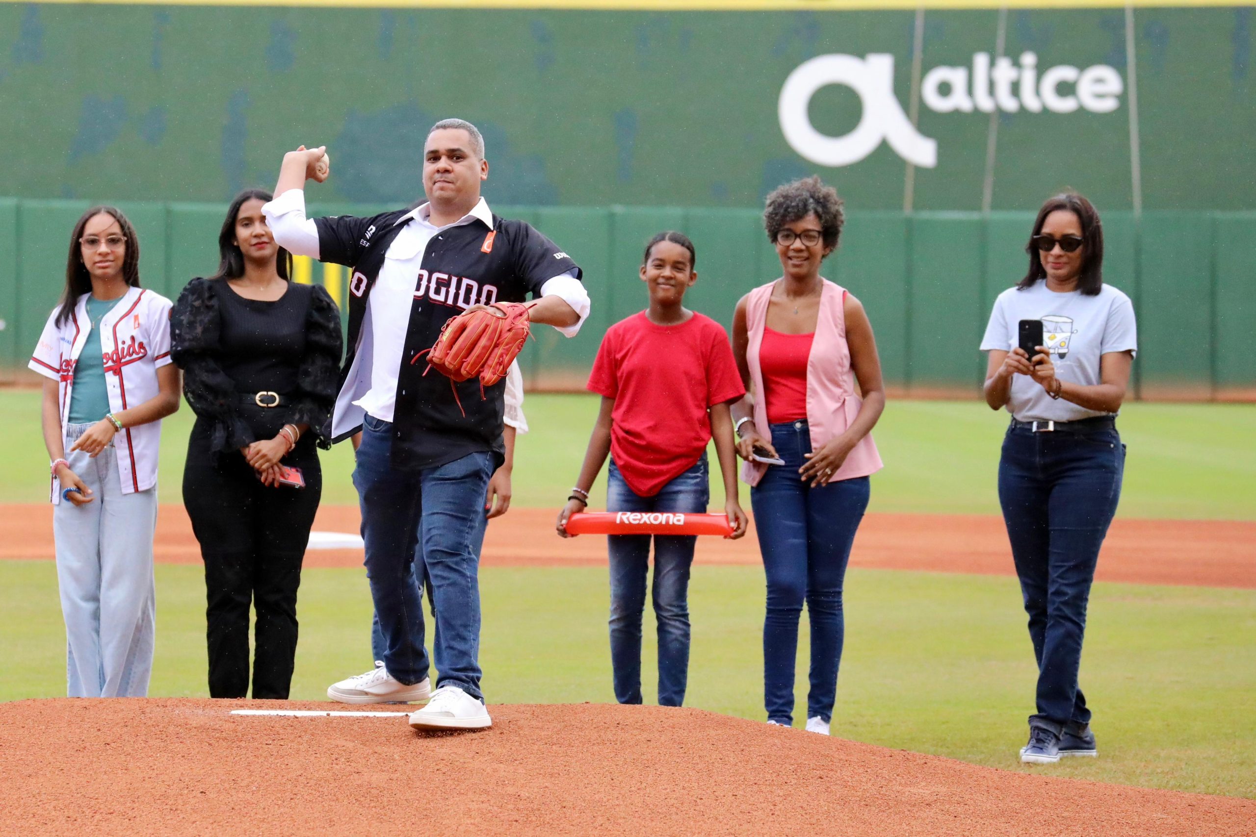 Erick Guzmán lanza la primera bola en el juego entre Escogido y Licey